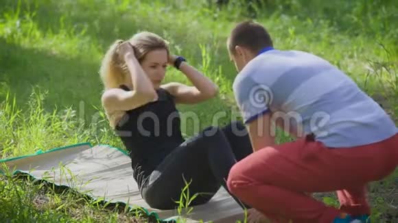 女人在公园里做腹部腹肌按压运动视频的预览图