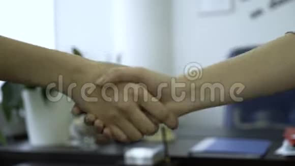 办公室背景下的握手特写良好的商业交易与握手建立了伙伴关系两个同事视频的预览图