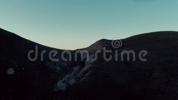 空中无人机从暗影谷飞到充满阳光的山脉视频的预览图