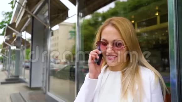 穿着时尚服装的金发美女在外面聊天视频的预览图