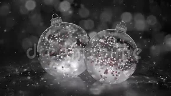 两个旋转的圣诞白色冰玻璃包雪红球背景循环视频的预览图