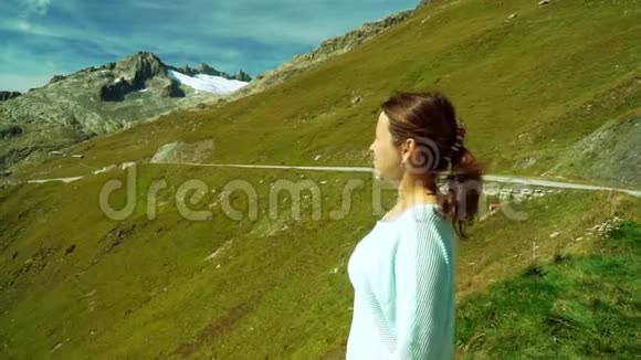 可爱的女孩从瑞士阿尔卑斯山的Furka山口观看全景视频的预览图