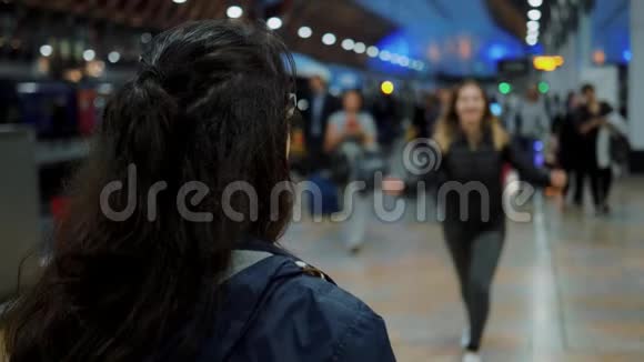 快乐的女孩在到达火车站时拥抱她的朋友慢镜头视频的预览图