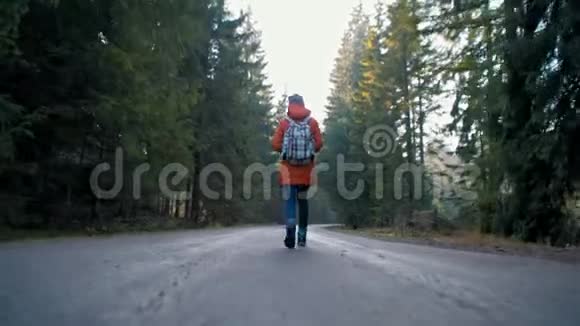 带背包的年轻女士正走在秋天森林的路上视频的预览图