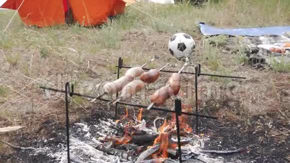 接近谁做肉香肠的镜头他们是在一个夏日的草地上的火中煎的火火烧得厨师视频的预览图
