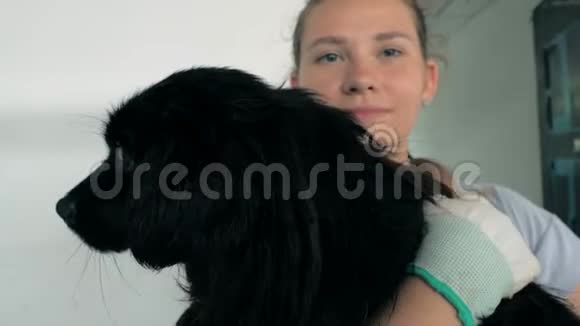 女志愿者的特写镜头在收容所里牵着狗动物收容所概念视频的预览图