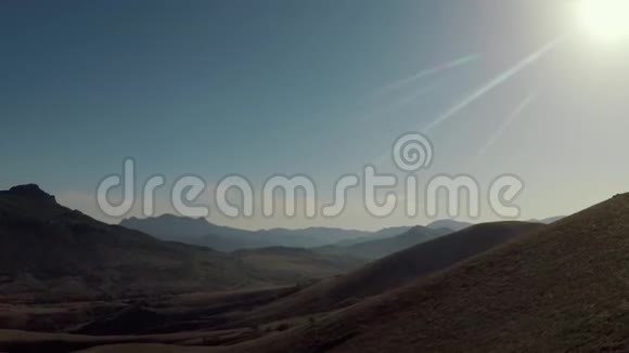 空中无人机飞行穿过山脉上方的山谷那里充满了阳光视频的预览图