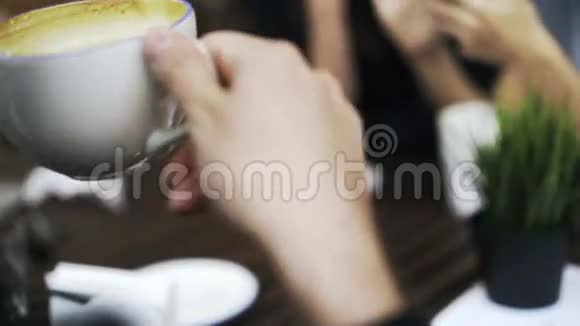 这家伙正在喝咖啡而他的女朋友在他们的社交媒体上在咖啡馆里视频的预览图