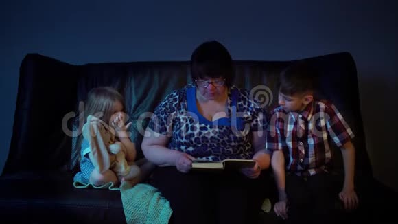 奶奶正在家里给孙子们读一本书视频的预览图