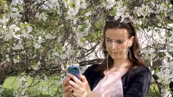 盛开的树木中的少女自拍视频的预览图