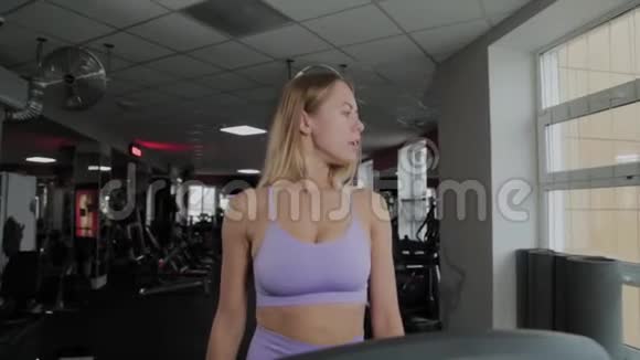 有着美丽身材的运动女性正在跑步机上训练视频的预览图