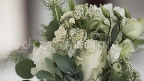 白色的花束玻璃花瓶里放着大绿叶放在白色的桌子上视频的预览图