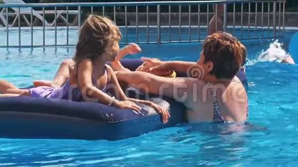 微笑快乐的孩子们在游泳池里的一个漂浮物上视频的预览图