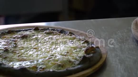 一家餐馆披萨饼桌子上的厨房里有三个现成的披萨它们又新鲜又热特写镜头慢慢视频的预览图