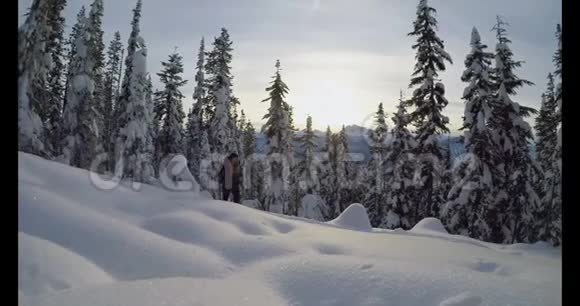 背着背包走在白雪覆盖的山坡上的女人视频的预览图