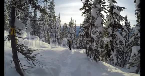 背着背包走在白雪覆盖的山坡上的女人视频的预览图