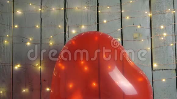 慢倾斜拍摄的爱的标志红色的心周围和灯红色的巴伦在背景情人节视频的预览图
