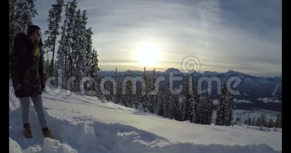 女子走在白雪覆盖的山坡4k视频的预览图