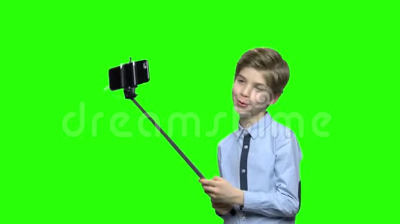 可爱的白种人男孩与自拍棒为相机摆姿势视频的预览图
