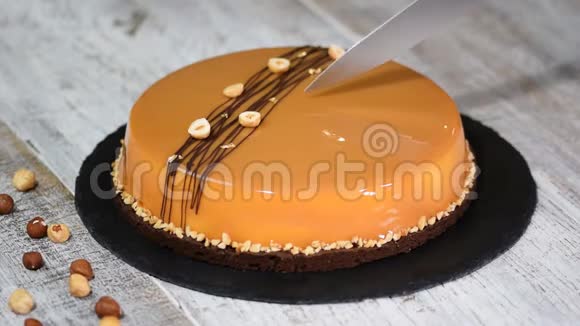 女性手切焦糖慕斯蛋糕焦糖蛋糕盘子里的摩丝甜点视频的预览图