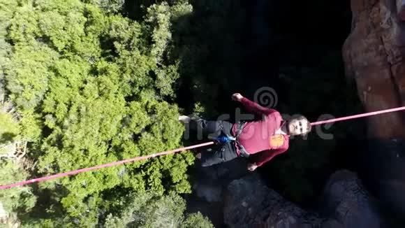 躺在四公里多岩石山上的绳索上的男式高空客机视频的预览图