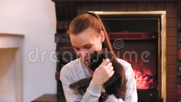 有只可爱的猫在壁炉旁休息的女人视频的预览图