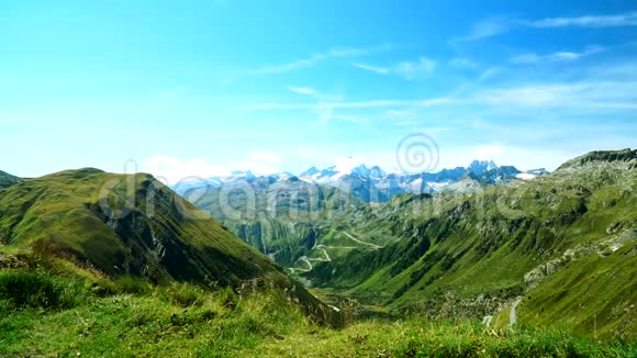 一个漂亮的女孩带着美丽的风景进入这个地方并在瑞士阿尔卑斯山的Furka通行证上感到高兴视频的预览图