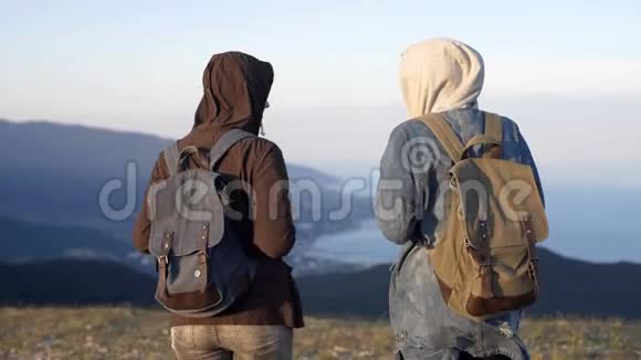 两位成功的背包客在山顶欣赏美丽的风景视频的预览图