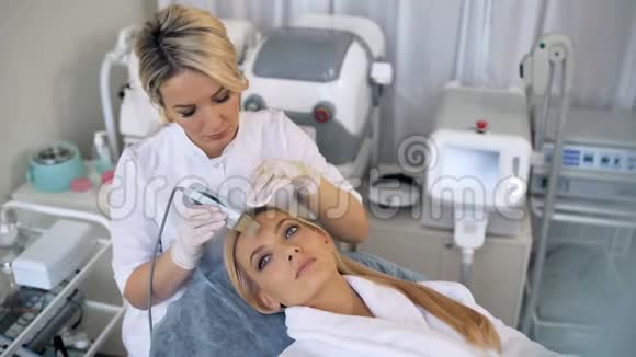 美容师为一位美丽的年轻美女做了面部皮肤超声波去皮手术视频的预览图