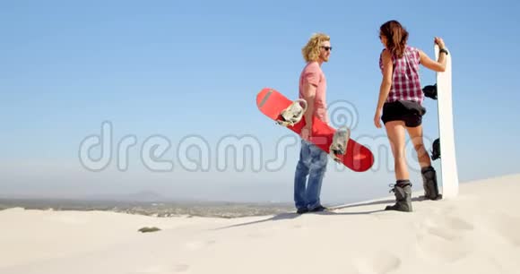 一对夫妇在沙漠里站着沙板视频的预览图