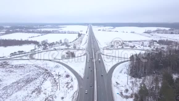 在雪道路口行驶的汽车和卡车视频的预览图