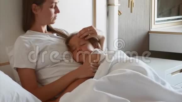 母亲和熟睡的孩子躺在床上在家里视频的预览图