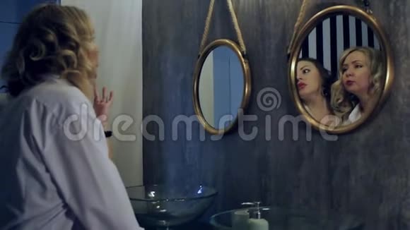 年轻漂亮的女人朋友在浴室的镜子附近笑得很开心两个穿内衣和白衬衫的女人视频的预览图