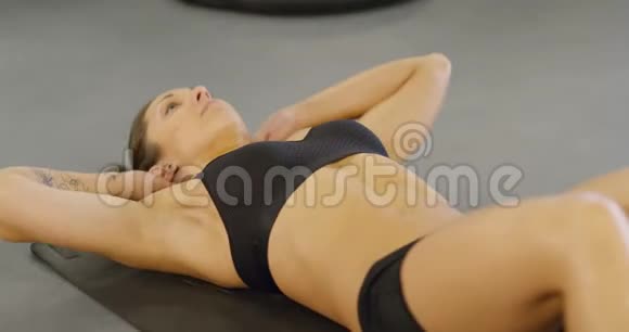 健身中心的健身妇女在地板上做仰卧起坐视频的预览图