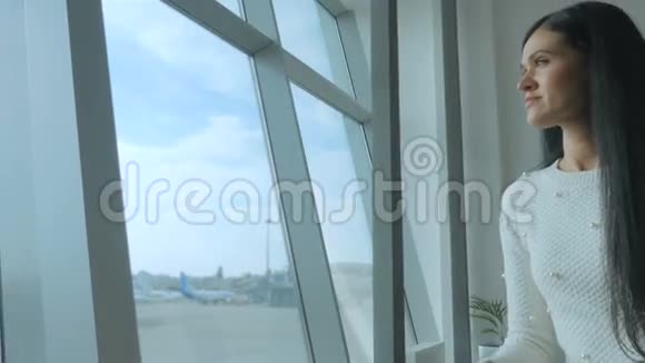 美丽的黑发女郎带着飞机在跑道上梦幻般地看着视频的预览图