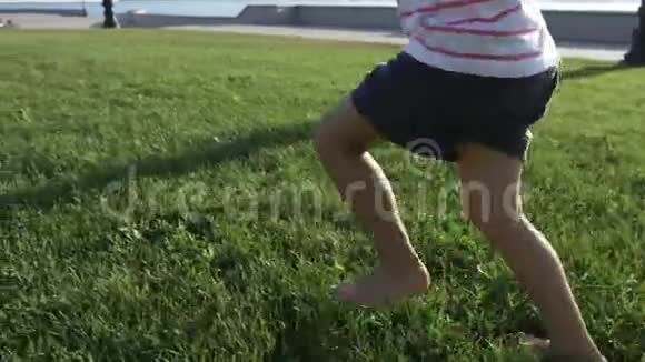 一个可爱的小女孩在城市公园的草地上奔跑视频的预览图