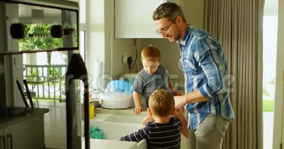 父亲和兄弟姐妹清洁厨房水槽4k视频的预览图
