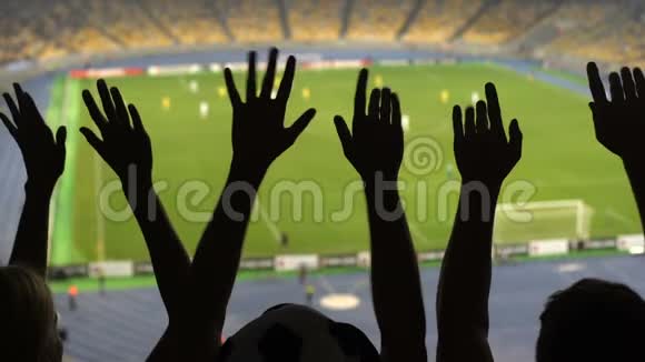 足球迷们在比赛期间手的剪影拥挤的足球场运动视频的预览图