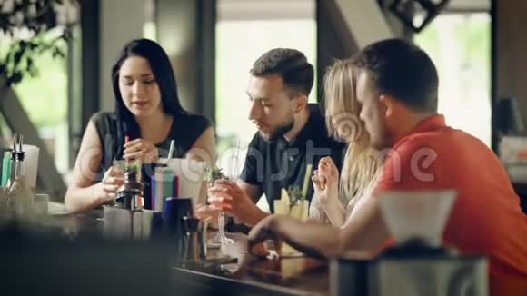 两对年轻夫妇在酒吧柜台喝鸡尾酒四个学生一起庆祝节日视频的预览图