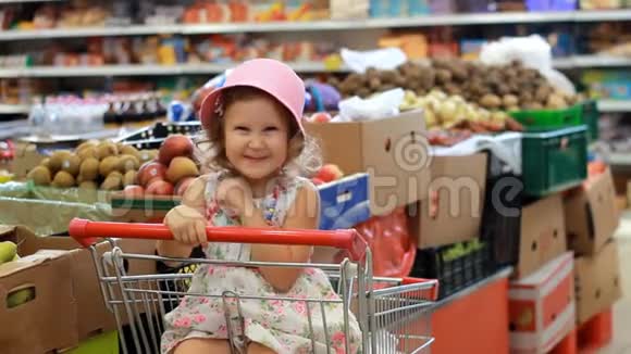 商店里的小女孩选水果杂货超市和购物车视频的预览图