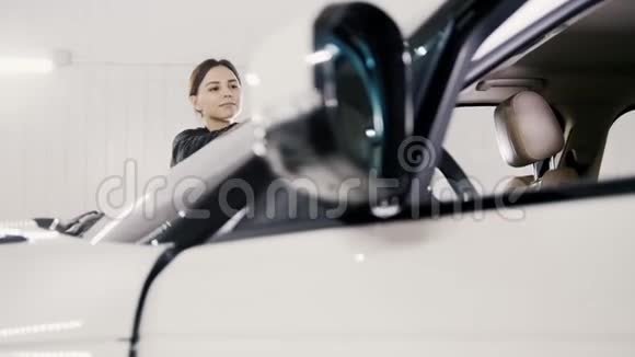 汽车细节迷人的年轻女子正在清洗一辆豪华车的挡风玻璃视频的预览图