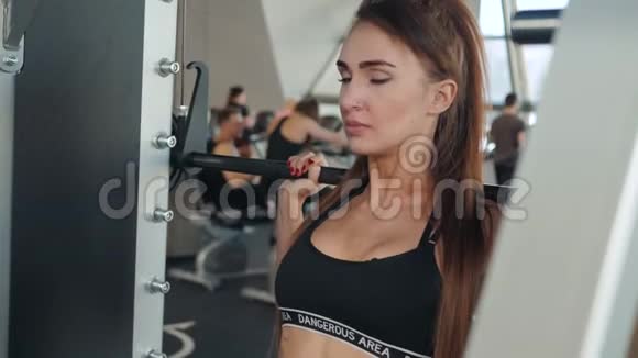肌肉发达的运动女性用哑铃来增强肌肉在健身房训练女孩用杠铃视频的预览图