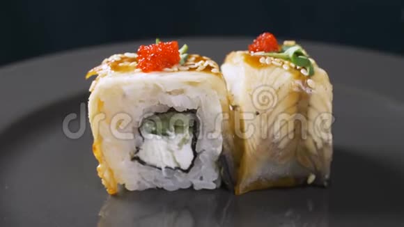 寿司卷在黑色背景上旋转寿司日本料理餐厅寿司卷配鲑鱼蔬菜视频的预览图