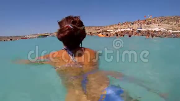 女孩在海滩背景下在海里洗澡女孩在蓝色的水里游泳水下射击马耳他视频的预览图