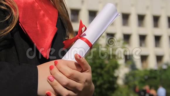 女子身着毕业礼服手持毕业证书展望幸福的未来视频的预览图