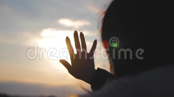 女孩在日落时用手看太阳视频的预览图