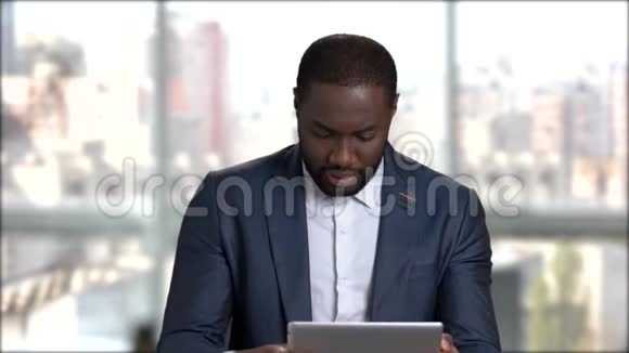 年轻英俊的商人在电脑平板电脑上玩视频的预览图