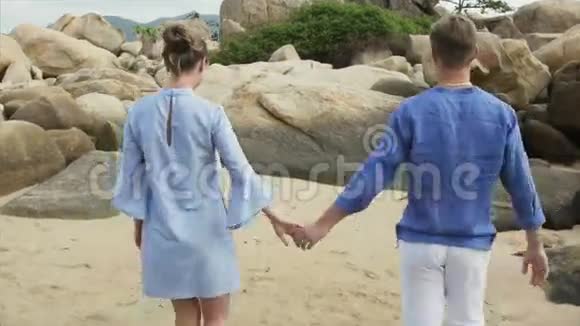 爱的男人和女孩交谈牵着手走在海边后景视频的预览图