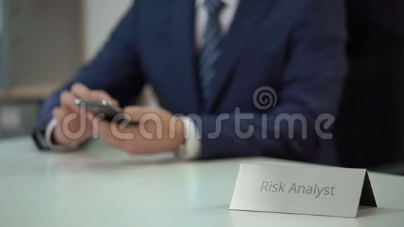 忙碌的男性风险分析师查看智能手机文件解决业务问题视频的预览图