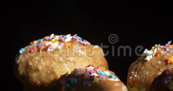 复活节蛋糕在黑色背景上一排撒着彩色的支架视频的预览图